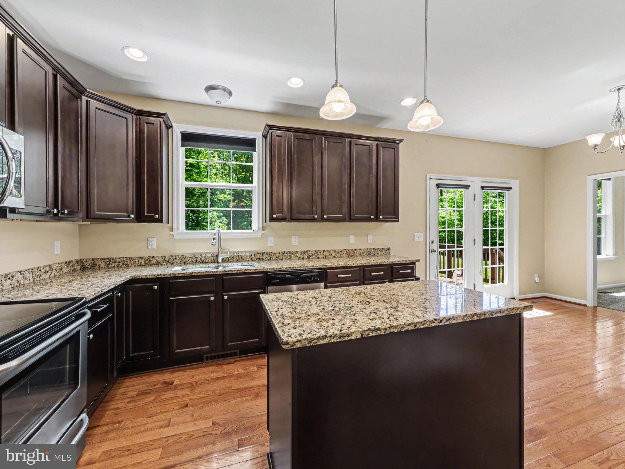 9811 Catharpin Road Spotsylvania, VA 22551 - Photo 9 of 30 a kitchen with large window a sink and wooden cabinets
