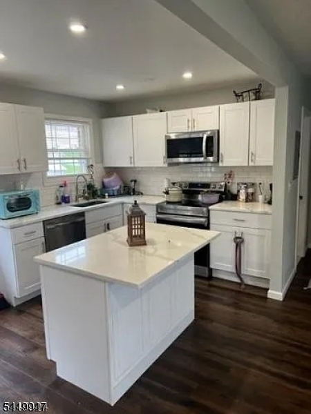 a kitchen with sink a microwave and cabinets