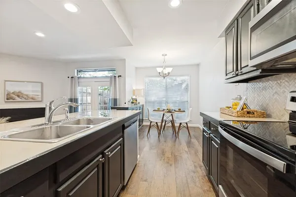a kitchen with stainless steel appliances granite countertop a sink stove and cabinets