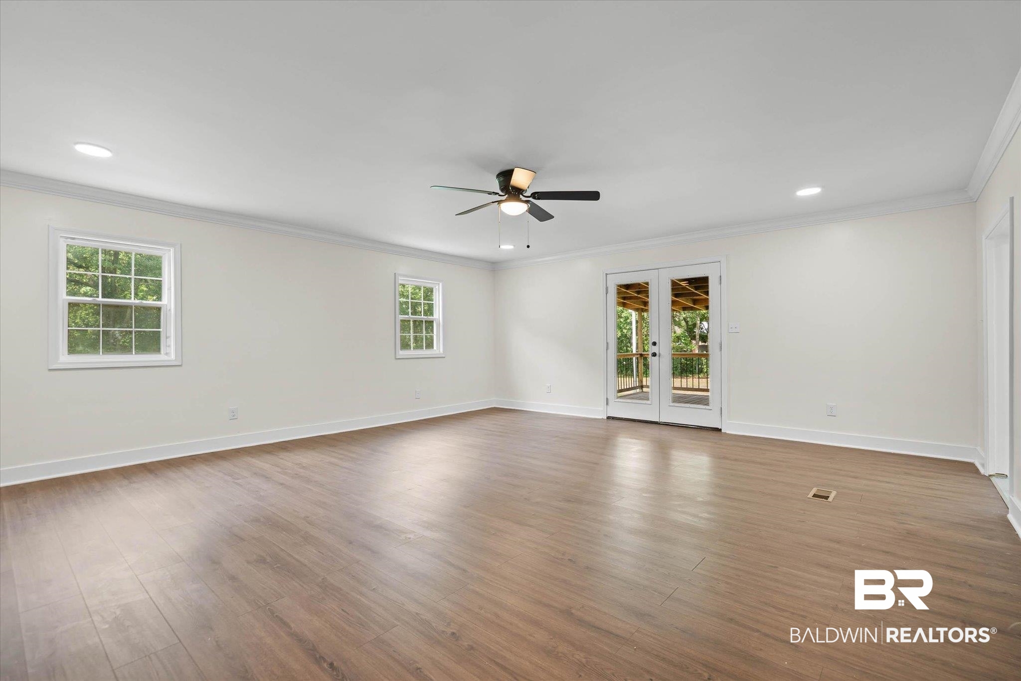 9230 McLeod Road Mobile, AL 36695 - Photo 10 of 20 Spacious room with wood-finish flooring, two large windows, recessed lighting, and a ceiling fan
