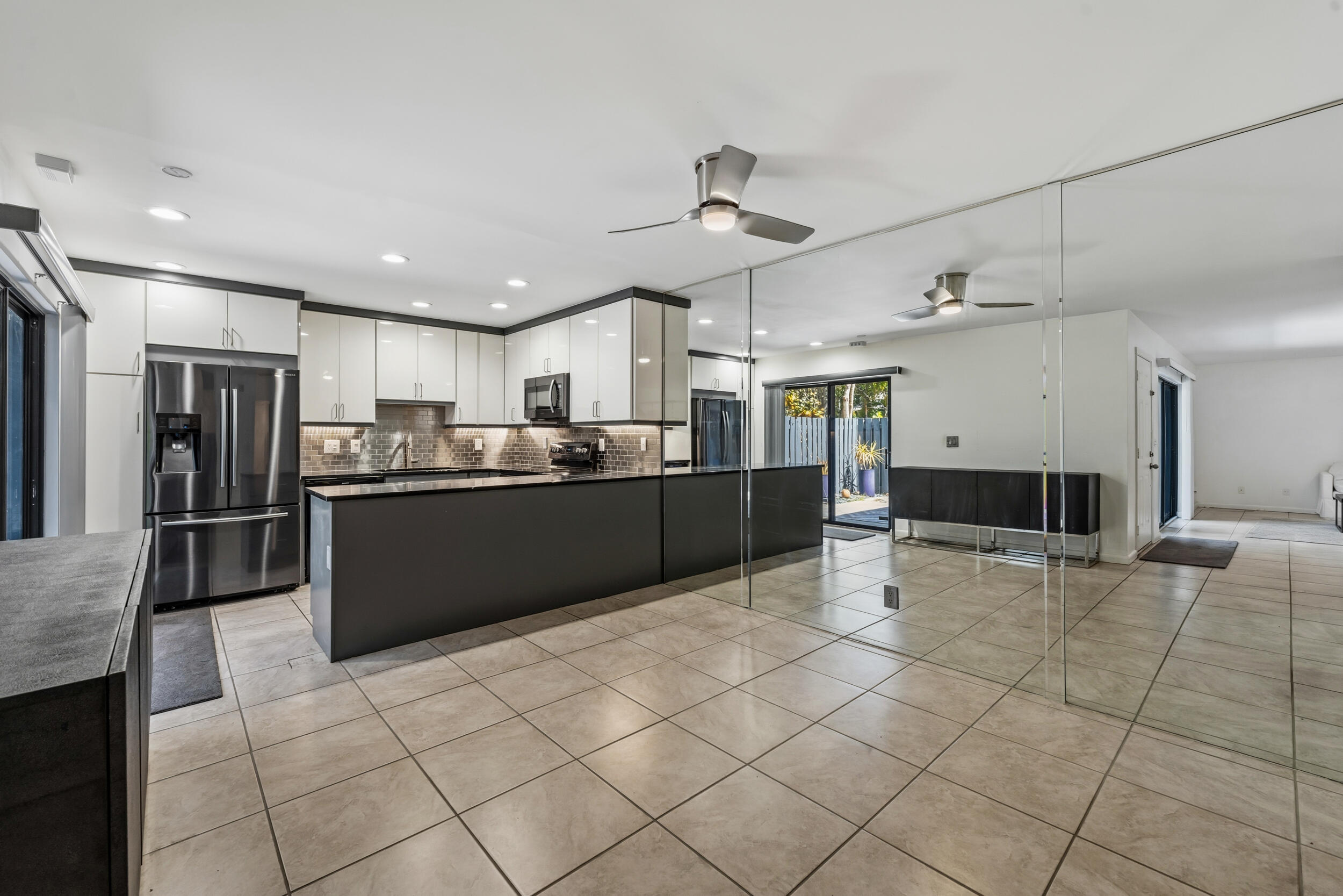 3852 Jefferson Street Stuart, FL 34997 - Photo 13 of 42 a kitchen with stainless steel appliances kitchen island granite countertop a refrigerator and a stove top oven