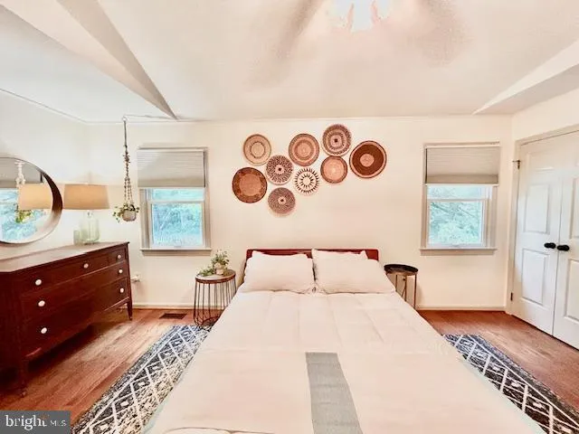 a bedroom with a bed and dresser with mirror