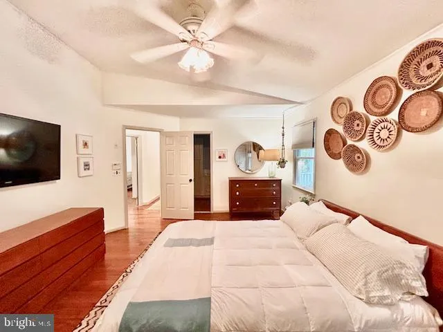 a spacious bedroom with a bed and a flat screen tv