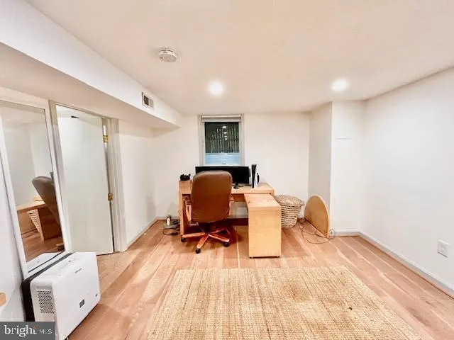 a view of a workspace with furniture and wooden floor