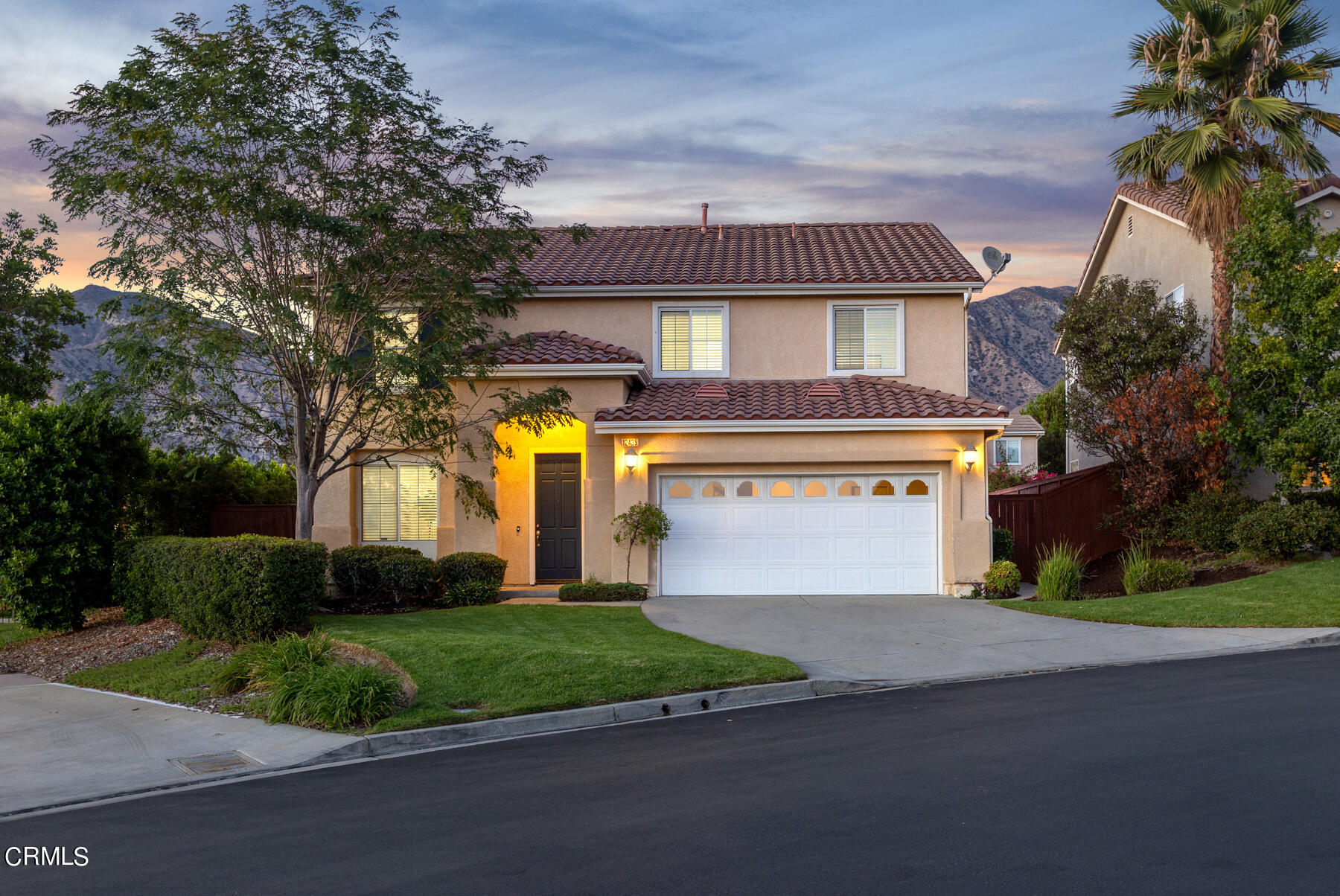 12435 Serrano Way Sylmar, CA 91342 - Photo 1 of 19 a front view of a house with a garden and garage