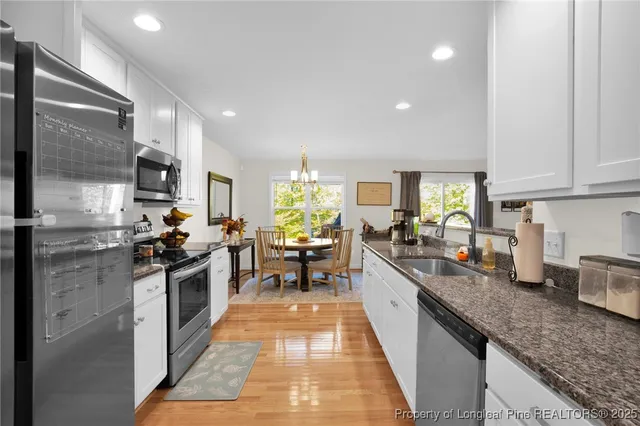 a kitchen with stainless steel appliances granite countertop sink stove top oven and refrigerator