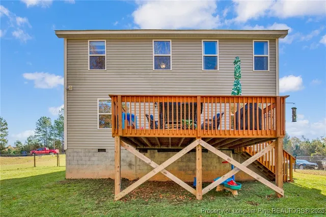 a view of an house with backyard and deck