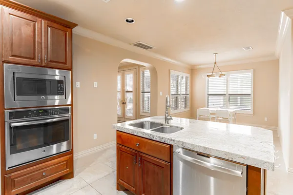 a kitchen with granite countertop a sink and stainless steel appliances