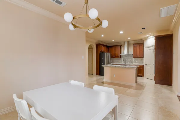 a large white kitchen with wooden floor and stainless steel appliances