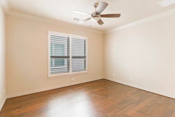an empty room with a window and a fan