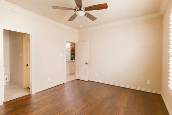 an empty room with wooden floor closet and windows