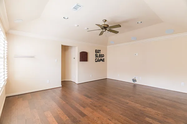 a view of an empty room with wooden floor