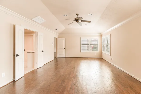 a view of an empty room with a window and wooden floor