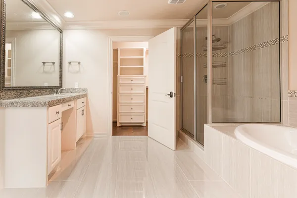 a bathroom with a granite countertop sink a mirror and a bathtub