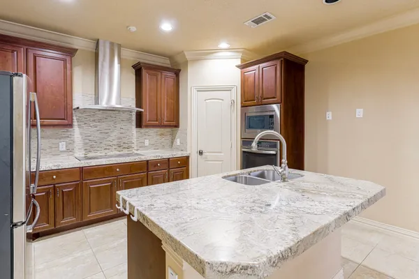 a kitchen with kitchen island granite countertop a sink stove and refrigerator