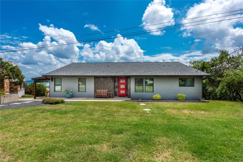 a view of a house with a patio and a yard