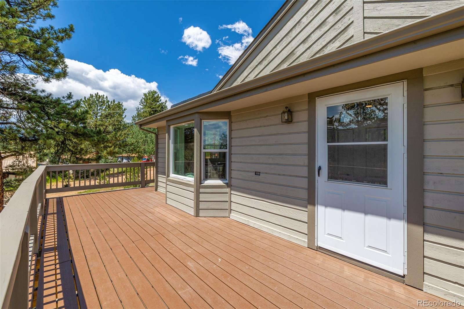 363 Neal Road Bailey, CO 80421 - Photo 30 of 39 a view of balcony with floor to ceiling window with wooden floor