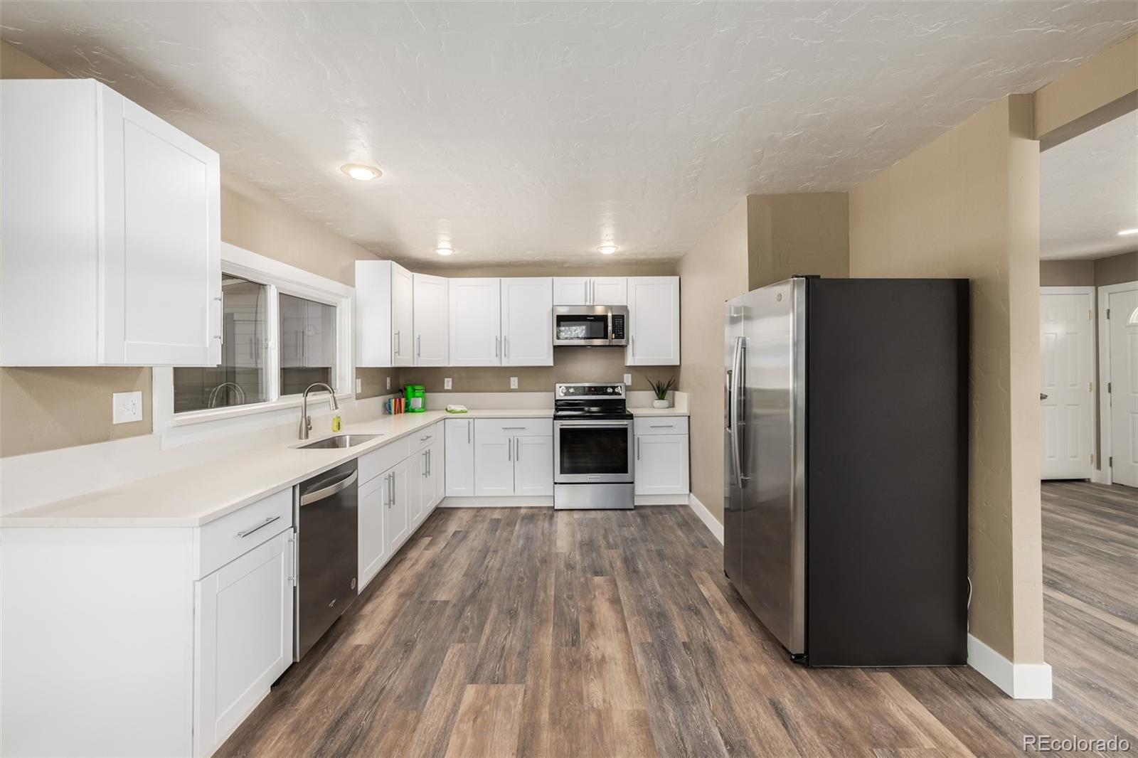 363 Neal Road Bailey, CO 80421 - Photo 9 of 39 a large kitchen with a center island wooden floor stainless steel appliances and cabinets