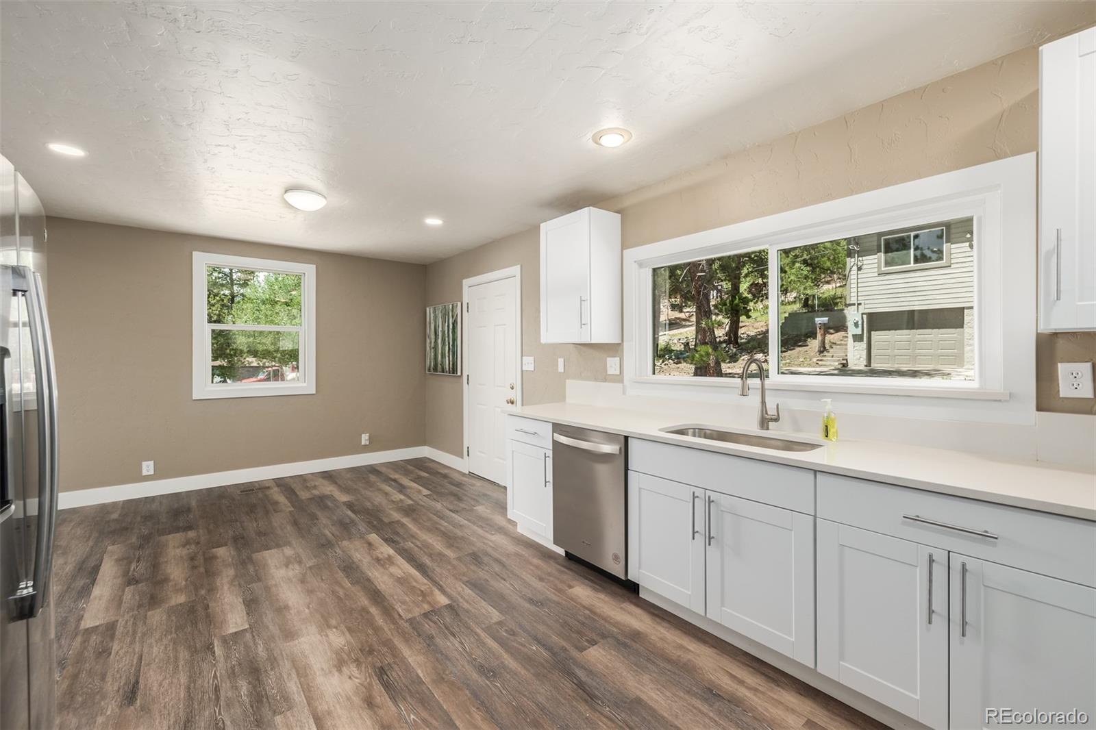 363 Neal Road Bailey, CO 80421 - Photo 10 of 39 a view of a kitchen with a sink dishwasher and wooden floor