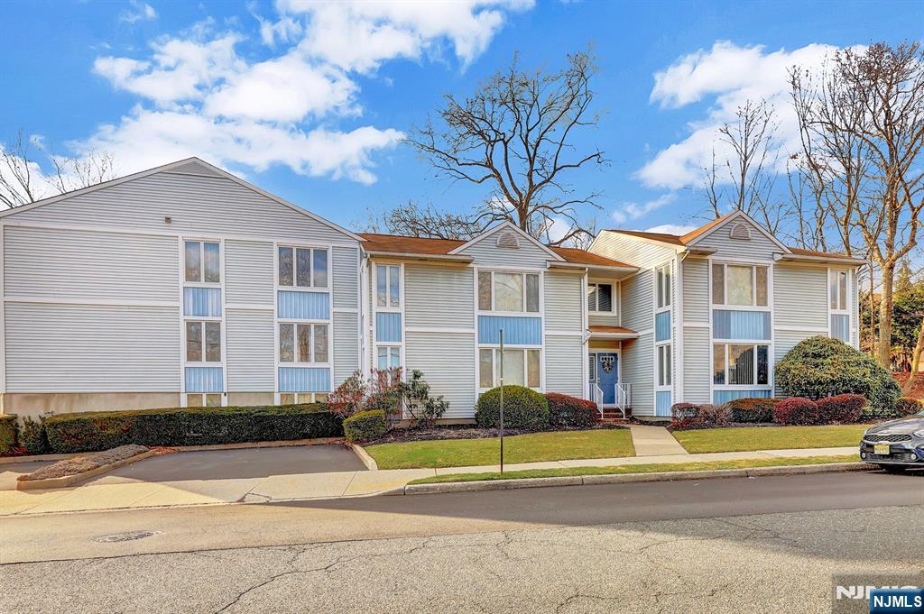 2 Grand Avenue, Unit 2 Hawthorne, NJ 07506 - Photo 8 of 8 a view of a white house with a large windows and a yard with plants and palm trees