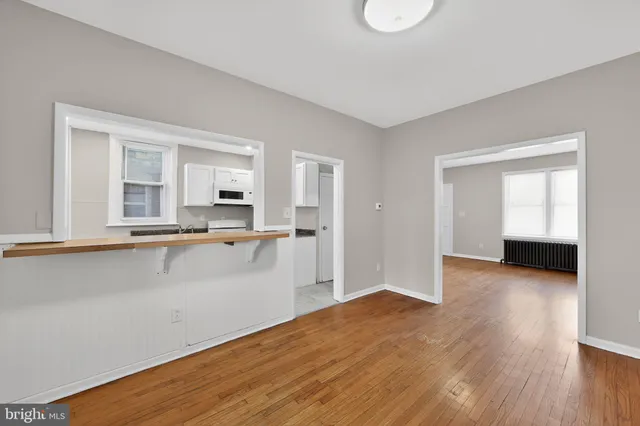 a view of a kitchen with wooden floor and a window