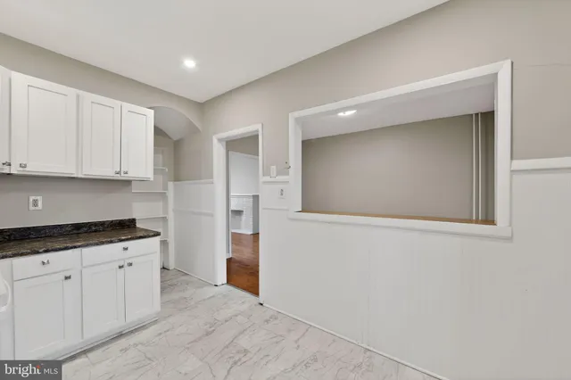 a kitchen with granite countertop white cabinets and white appliances