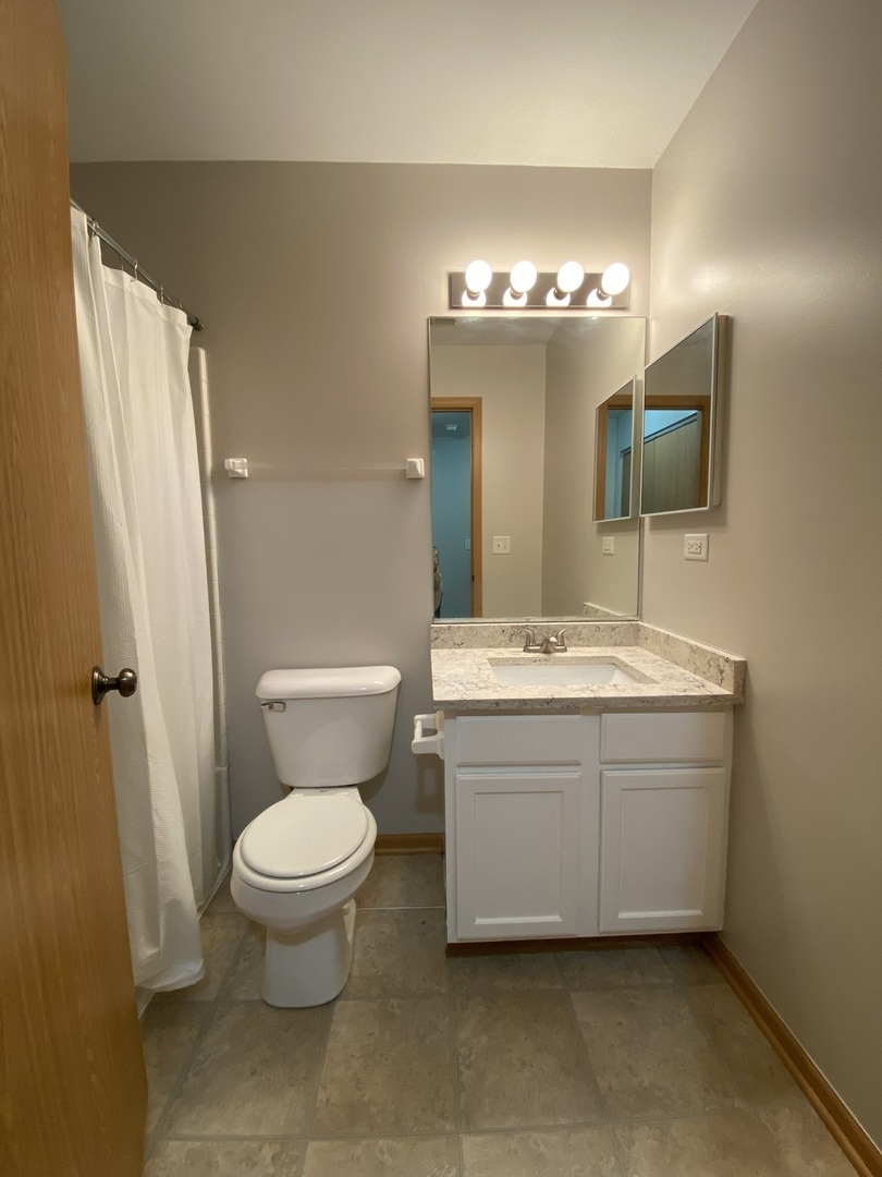 515 May Street Plano, IL 60545 - Photo 11 of 14 a bathroom with a toilet sink and mirror