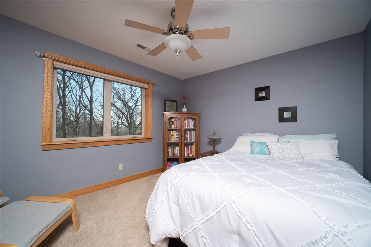 2685 Rogene Drive Oregon, IL 61061 - Photo 23 of 40 a bedroom with a large bed a chandelier and a window