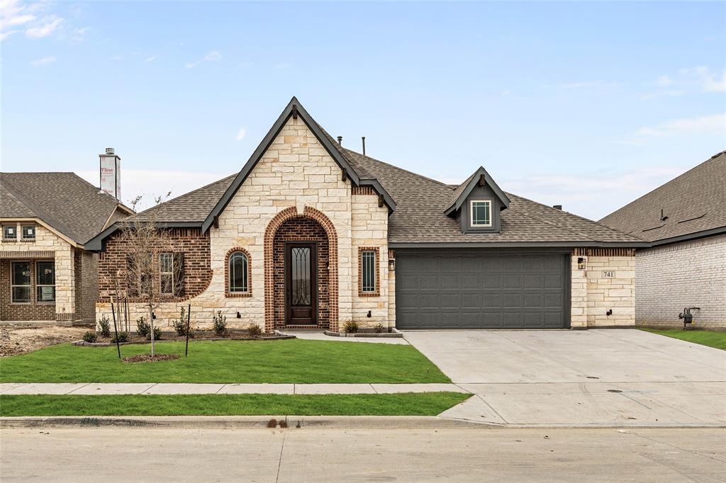 a front view of a house with a garden and garage