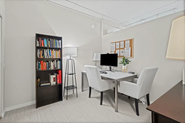 a view of a workspace with furniture and a bookshelf