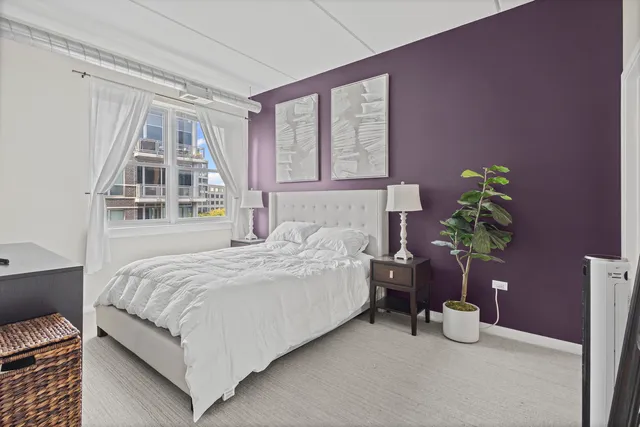 a bedroom with a bed table and a window