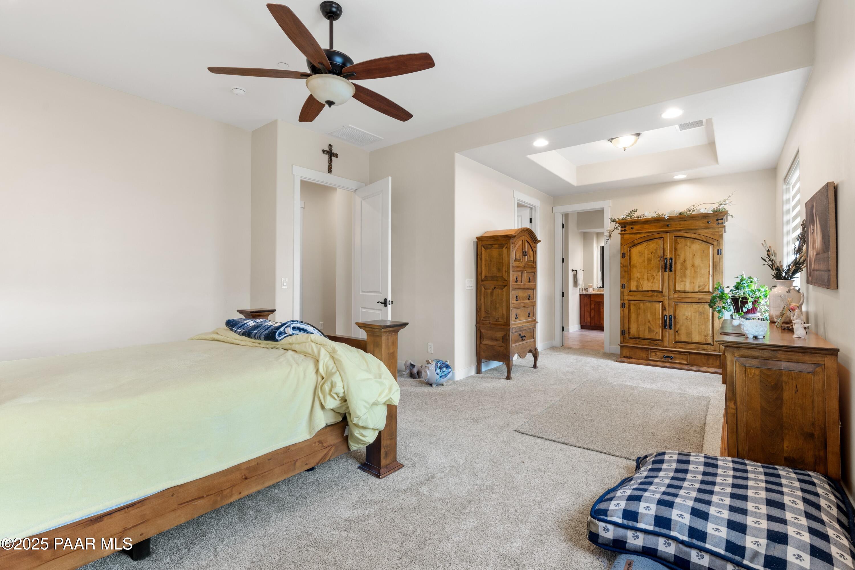 1468 Butte Road Prescott, AZ 86303 - Photo 18 of 31 a spacious bedroom with a bed and a chandelier