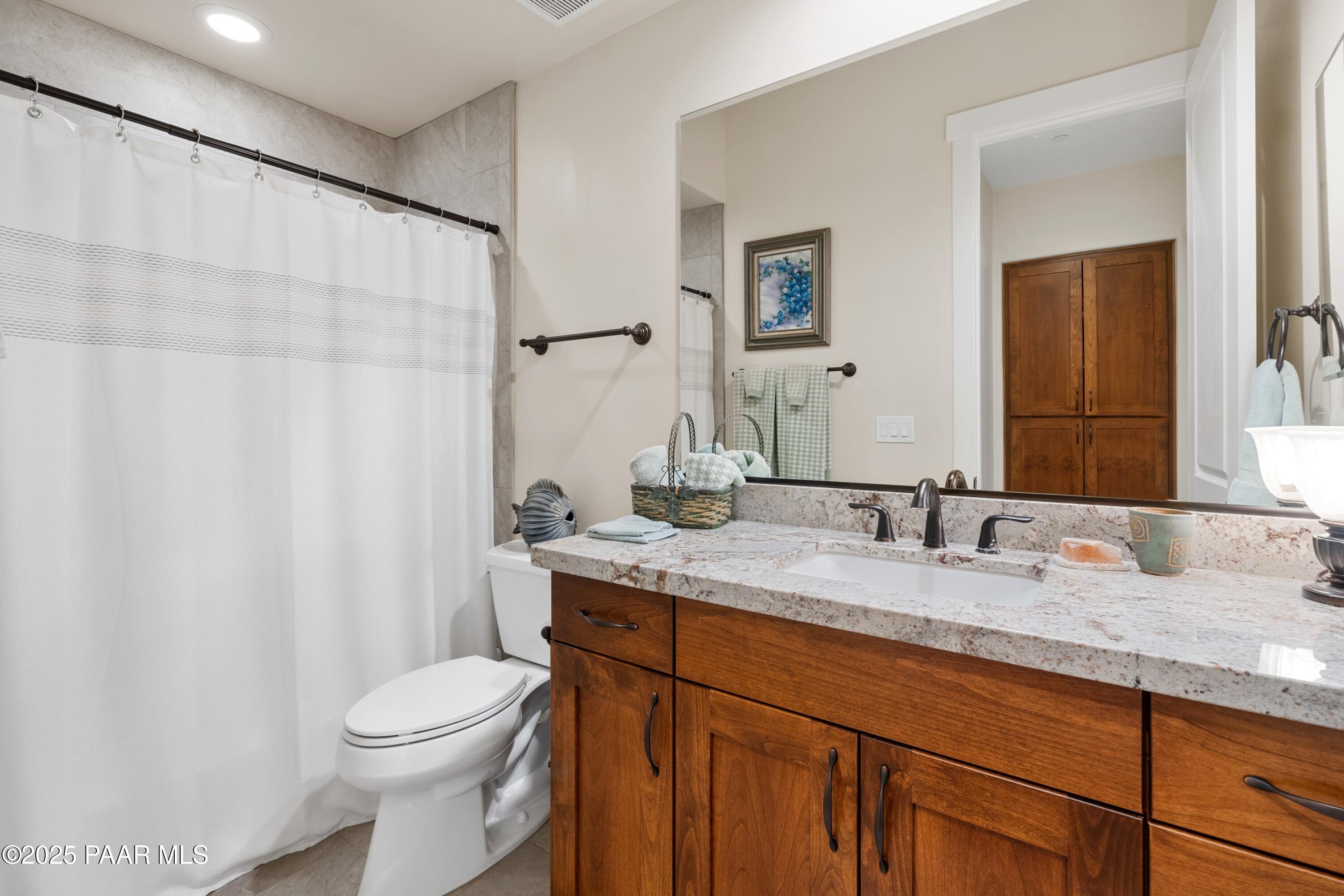 1468 Butte Road Prescott, AZ 86303 - Photo 22 of 31 a bathroom with a granite countertop sink toilet and mirror