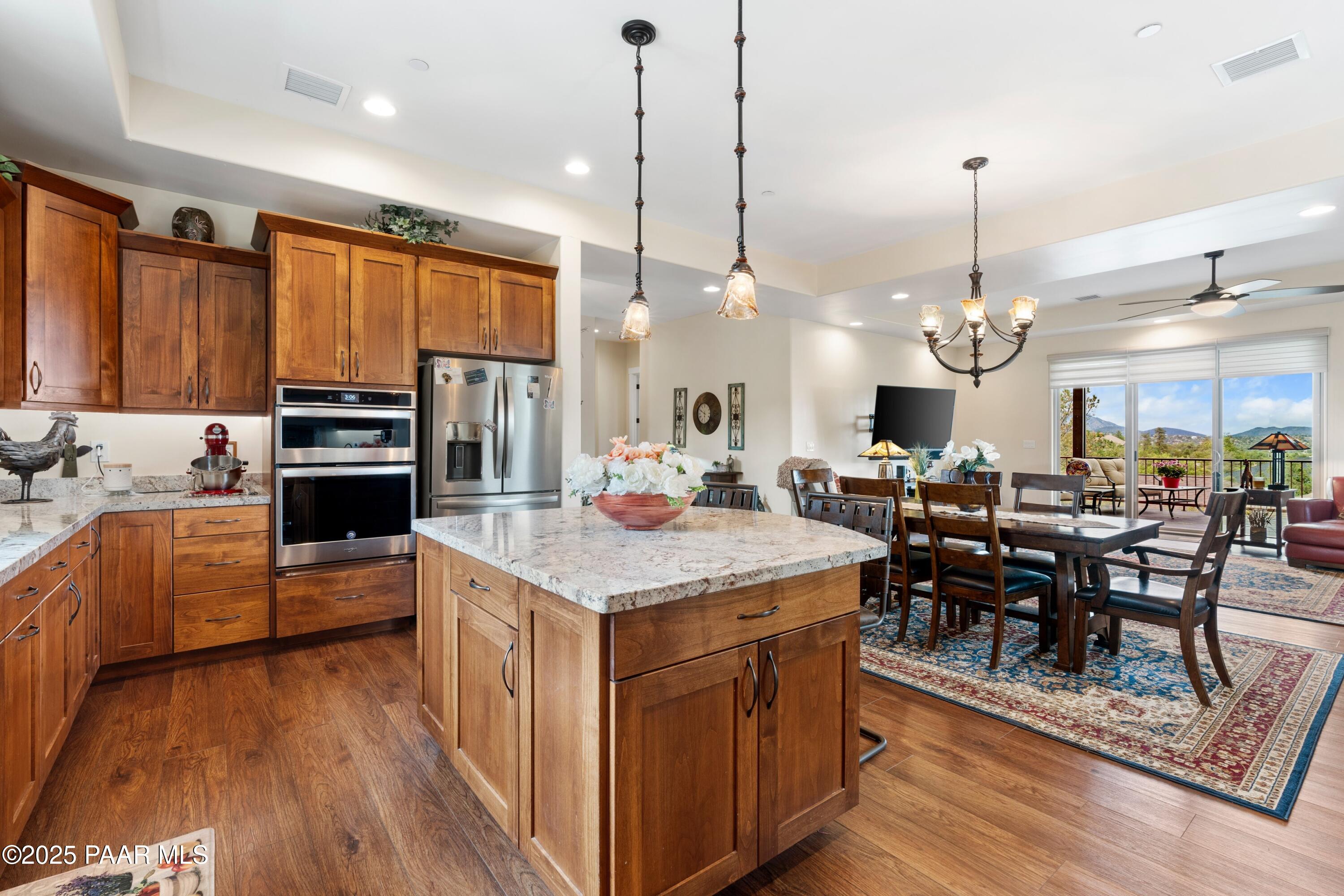 1468 Butte Road Prescott, AZ 86303 - Photo 9 of 31 a kitchen with stainless steel appliances granite countertop a stove oven a refrigerator a oven a dining table and chairs with wooden floor