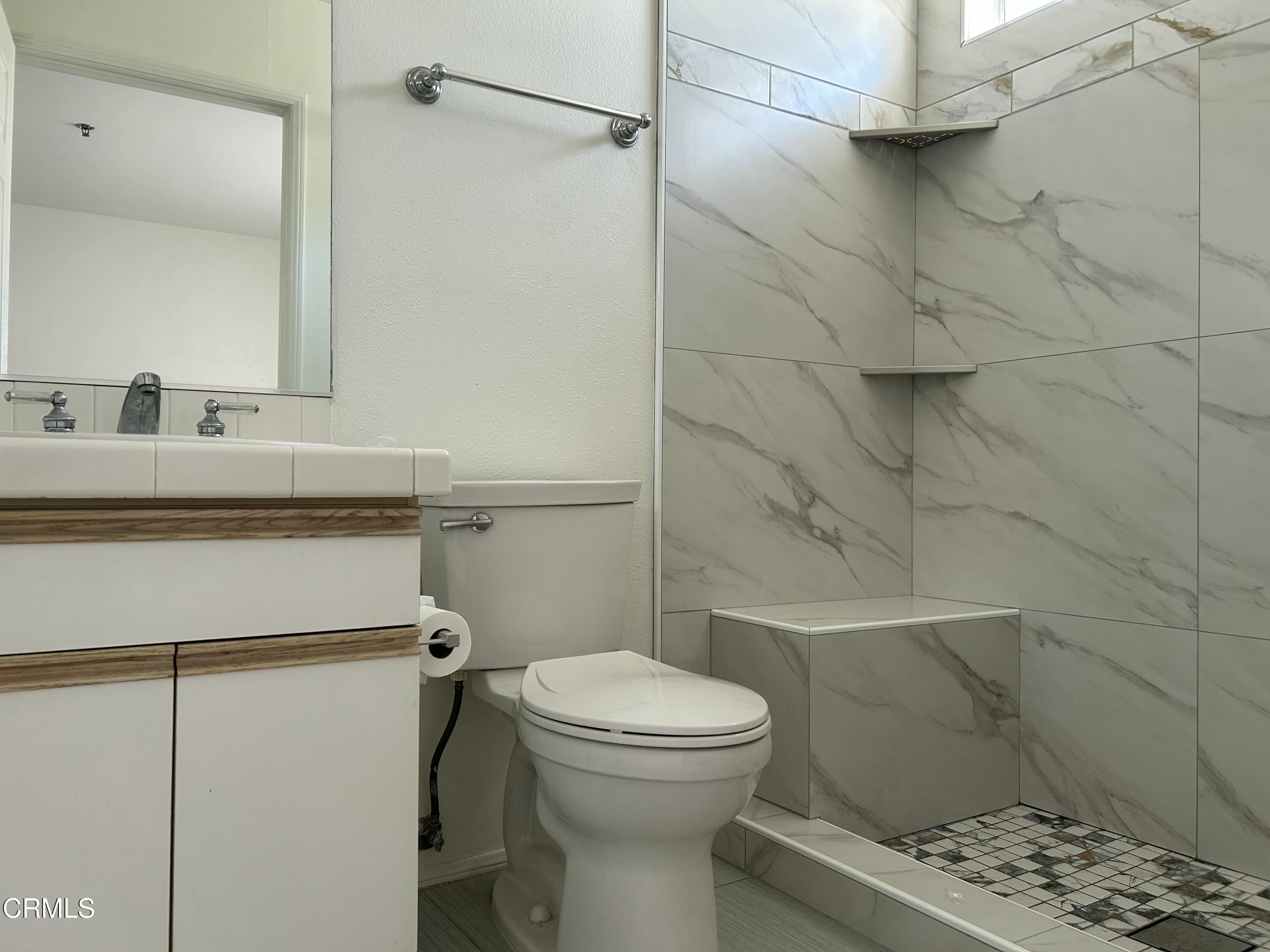10925 Blix Street, Unit 102 Toluca Lake, CA 91602 - Photo 19 of 29 a bathroom with a granite countertop toilet sink and shower