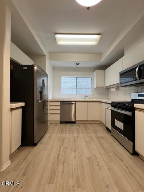 10925 Blix Street, Unit 102 Toluca Lake, CA 91602 - Photo 7 of 29 a large kitchen with stainless steel appliances granite countertop a refrigerator and a stove top oven
