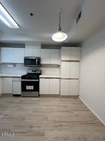 a kitchen with stainless steel appliances a stove and cabinets