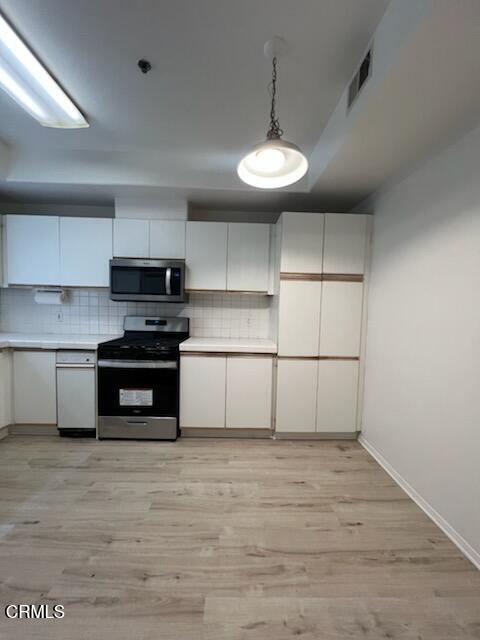 10925 Blix Street, Unit 102 Toluca Lake, CA 91602 - Photo 8 of 29 a kitchen with stainless steel appliances a stove and cabinets