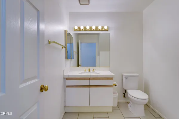 a bathroom with a sink a toilet and mirror