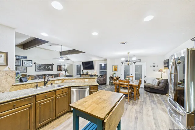 a kitchen with stainless steel appliances kitchen island granite countertop a sink and cabinets