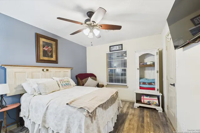 a bedroom with a bed and a flat tv screen on dresser