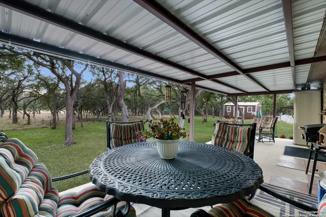 a view of a porch with furniture and a yard