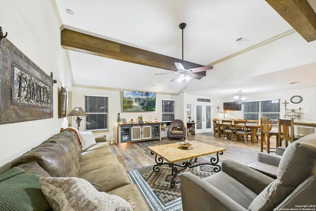a living room with furniture kitchen view and a large window