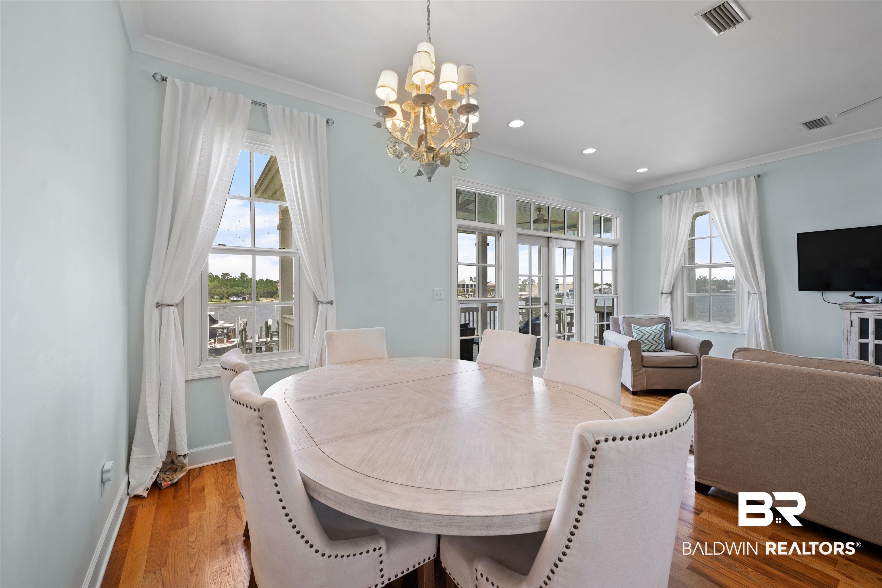 3434 Mariner Circle Orange Beach, AL 36561 - Photo 21 of 38 Dining room with wood-type flooring, ornamental molding, and an inviting chandelier.