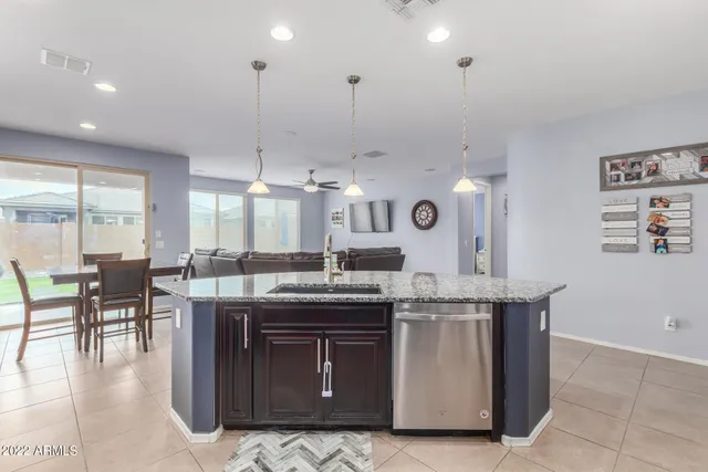 a kitchen with stainless steel appliances granite countertop wooden cabinets a dining table and chairs