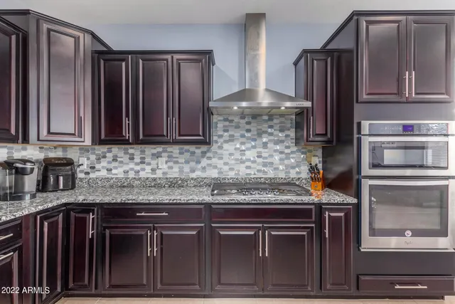 a kitchen with granite countertop stainless steel appliances and cabinets