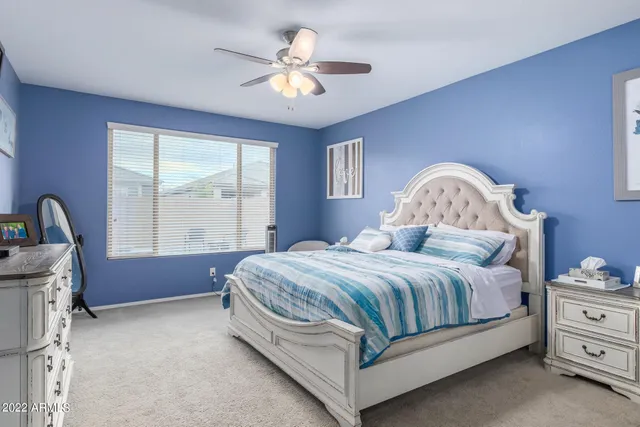 a spacious bedroom with a bed table and window