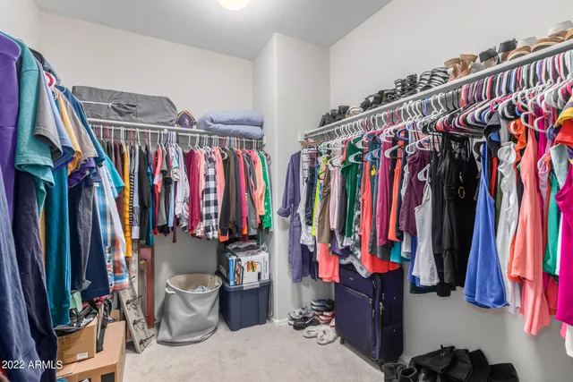 a view of walk in closet with clothes and shoes