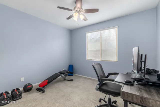a view of a workspace with furniture and a window
