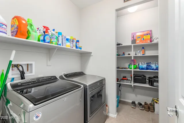 a utility room with lots of clutter and cabinets